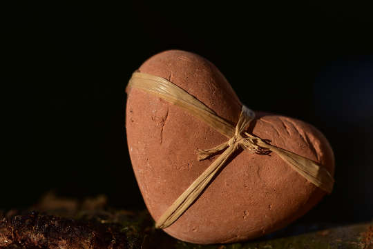 a heart made of stone with a ribbon around it