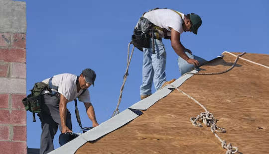 dois homens trabalhando em um telhado