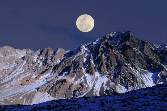 lua cheia sobre uma montanha