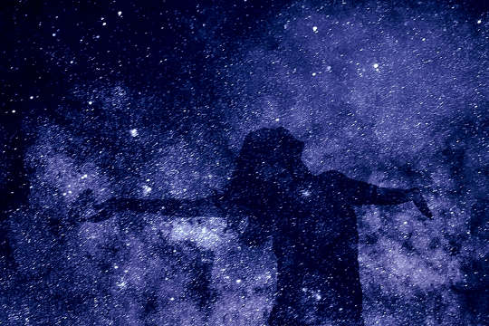 yıldızlı bir galaksinin arka planına yerleştirilmiş bir kadının silueti