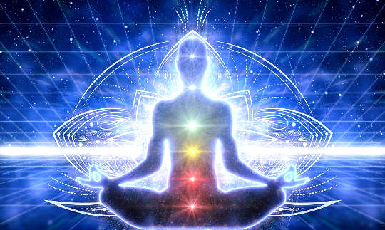 egy meditációban lévő személy kivilágított csakrákkal és energiavonalakkal a teste körül