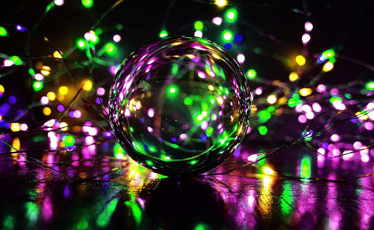una sfera di cristallo riempita e circondata da puntini di luce