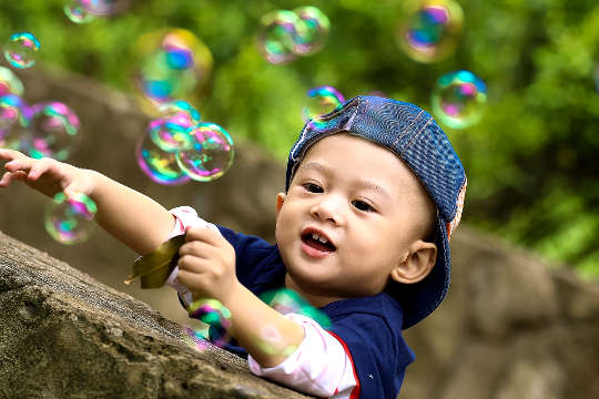 a young boy surrounded by soap bubbles
