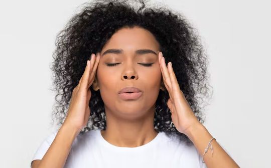 a woman holding her head looking stressed