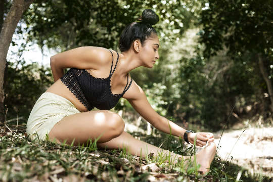 una donna in una posa yoga seduta fuori nella natura