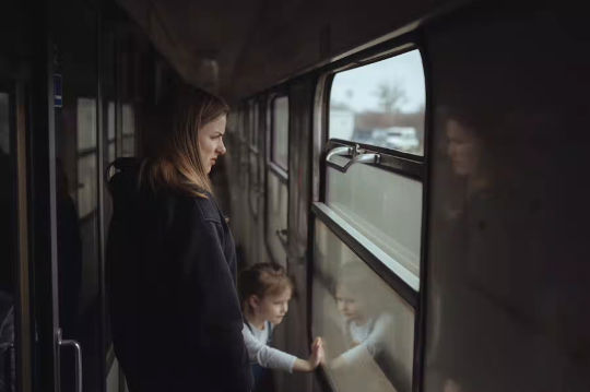 Seorang ibu dan anak perempuan Ukraina di kereta saat mereka melarikan diri dari perang