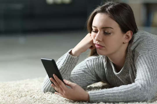 אישה צעירה משתמשת בטלפון החכם שלה