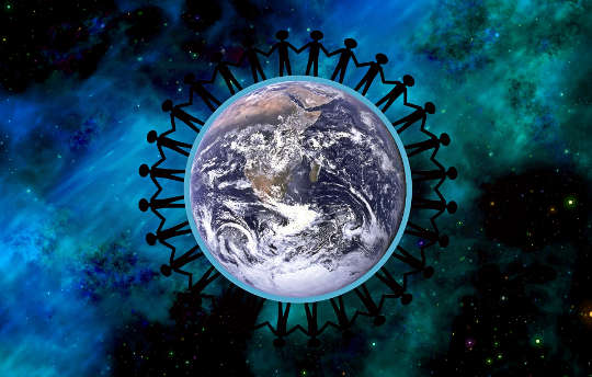 en sirkel av mennesker som holder hendene rundt planeten Jorden