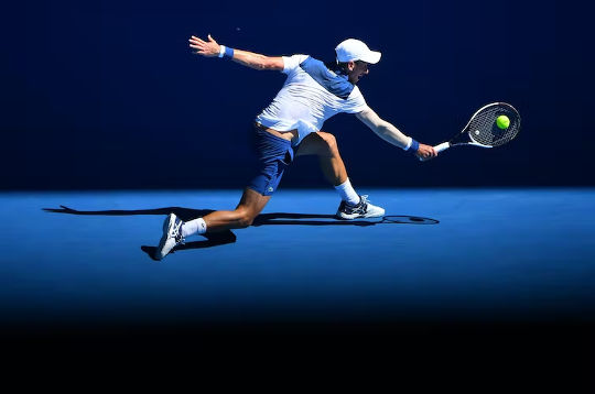 运动员在澳大利亚网球公开赛上用球拍击球