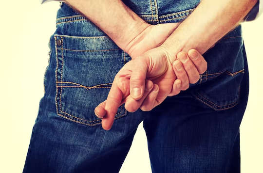 व्यक्ति अपने हाथों को अपनी पीठ के पीछे करके खड़ा होता है और उनकी उंगलियां क्रॉस हो जाती हैं