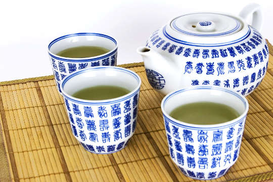 teh yang dibengkokkan dalam cawan tradisional dan teko