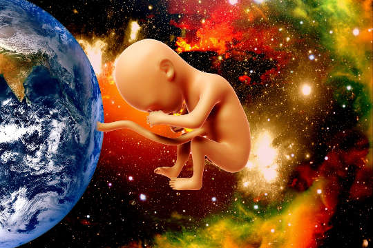 a picture of Planet Earth with a baby linked to it by an umbilical cord