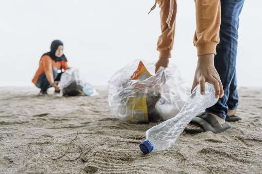 Musulmanes recogiendo botellas de plástico en el suelo