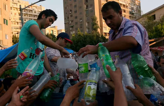 プラスチック製の飲料水ボトルを補充する人々