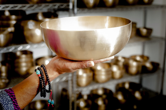 hands holding a large singing bowl