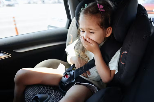 lapsi sairastaa matkapahoinvointia auton istuimessa