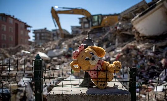 Et utstoppet leketøy på stedet for kollapsede bygninger etter jordskjelvet i Hatay, Tyrkia