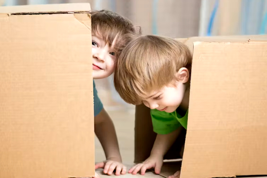 Kinder spielen mit und in Kisten