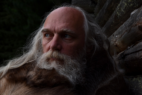 foto af ældre hvid mand med skæg og strømmende langt hår
