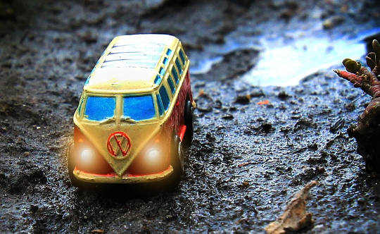gul Volkswagen skåpbil på en blöt bergsterräng