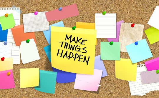 bulletin board na may post it note na may malalaking letra: MAKE THINGS HAPPEN