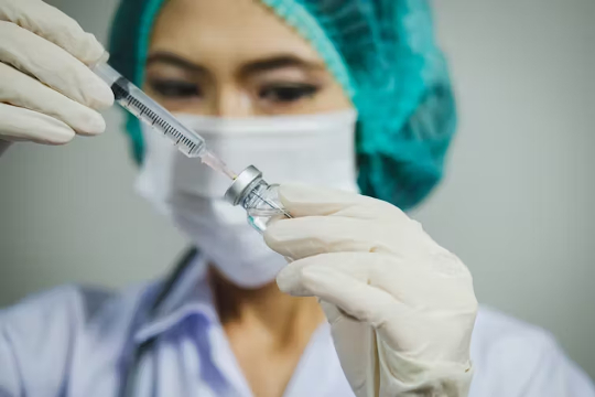 Krankenschwester bereitet eine Nadel für die Impfung vor