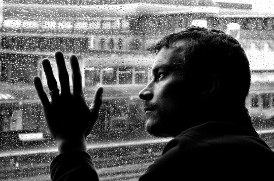 un bărbat care se uită pe fereastră