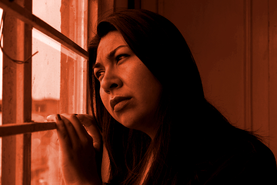 en kvinde kigger ud af et vindue