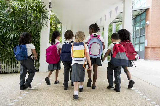 okula yürüyen bir grup küçük çocuk