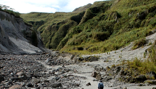 isang rough trail sa mga bundok na may nag-iisang hiker