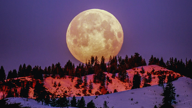 צילום של פרנק קון: ירח על מעל הרים מושלגים.