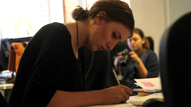 mujer joven sentada en un escritorio en profunda concentración