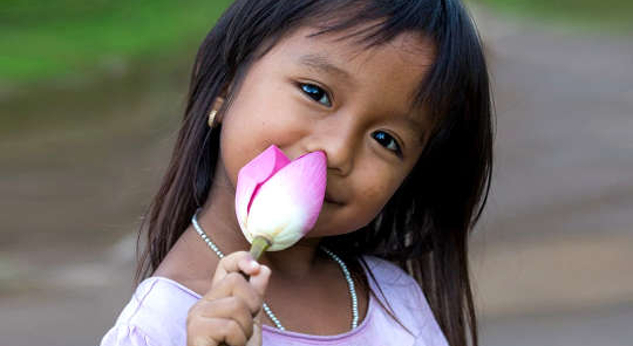 gadis muda memegang bunga teratai yang belum dibuka
