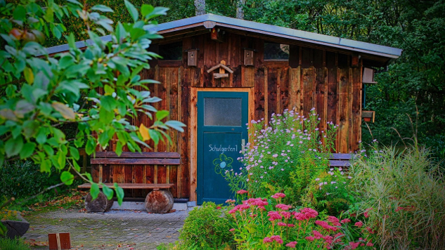 una pequeña casa de madera en un jardín