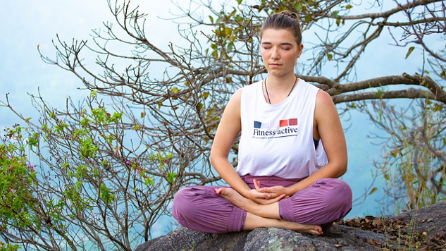 jonge vrouw zit buiten in een meditatiepositie