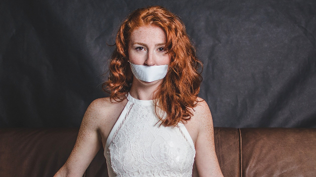 vrouw in avondjurk tot zwijgen gebracht met tape op haar mond