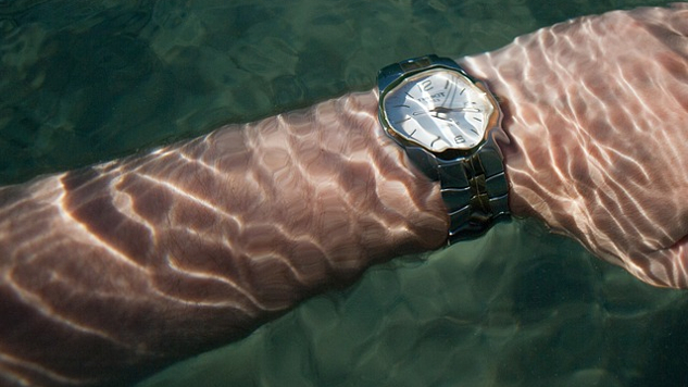 un braccio che indossa un orologio da polso sott'acqua