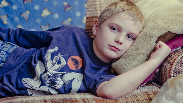 расстроенный мальчик лежит на диване