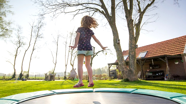 jong meisje dat op een trampoline springt
