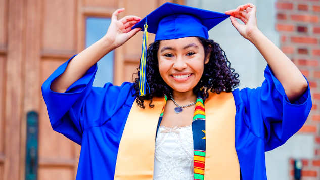 一位年輕女子自豪地戴著藍色畢業帽和禮服