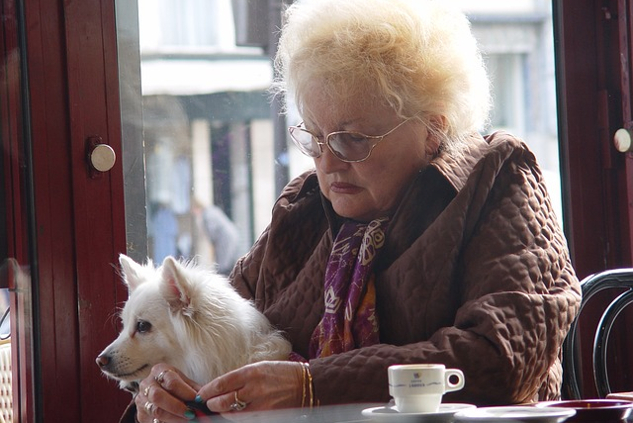 vanha nainen pitelee koiraa sylissään