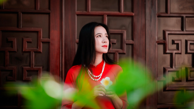 mujer joven con un vestido rojo mirando al cielo