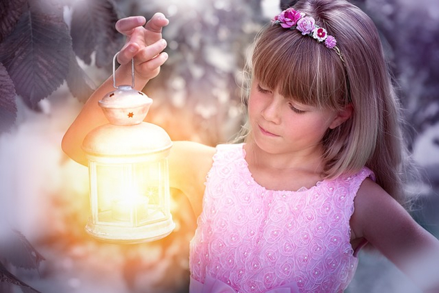 ein Mädchen hält eine hell leuchtende Laterne hoch