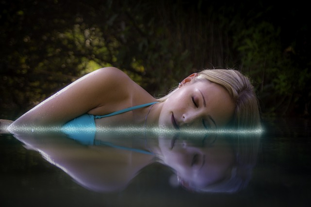 nainen makaamassa, nukkumassa vedessä
