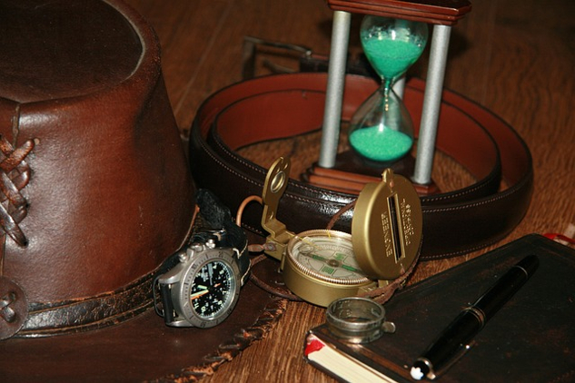 et timeglass, et kompass, en penn og en notatbok