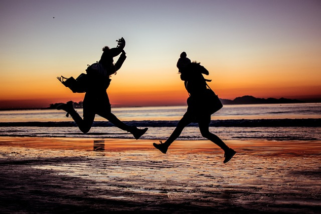 two people jumping with joy at the beach