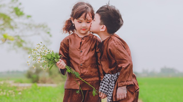 a young boy and girl, boy kissing girl on the cheek