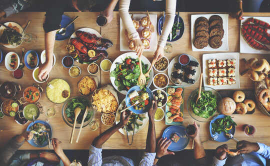 Una mesa de amigos comiendo una variedad de platos de comida.