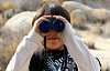 young boy looking through binoculars
