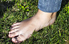 изображение босой ноги человека, стоящего на траве